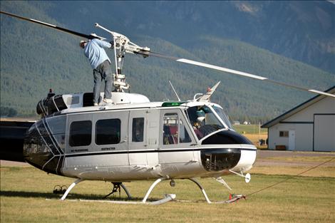 John Easter, mechanic with Vigilante Helicopters, makes a routine rotor check at Ronan Airport Friday after refueling the helicopter assigned to drop water on the Eagle Pass fire.