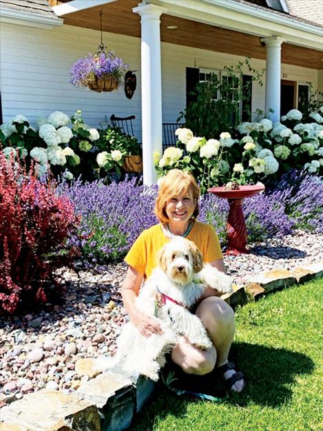 Koylyn Sinclair poses with a furry friend in front of her award winning garden.