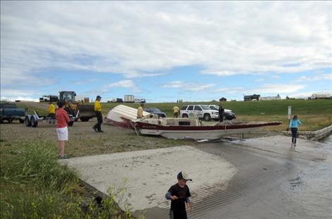 A boat is hauled out of the Flathead River after a storm sank it Tuesday night, Aug. 14.