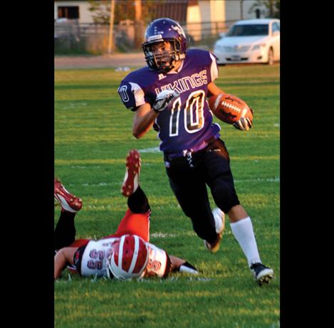 Trent Dennison avoids a tackle as he runs for first down yardage.