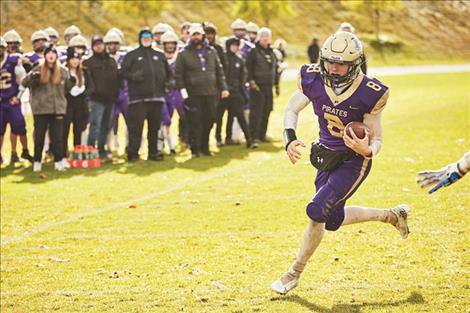 Polson Pirate quarterback Jarrett Wilson runs the ball down the field. Wilson was recently named a $1,000 Heisman High School Scholarship winner. (See related story on page 17.)