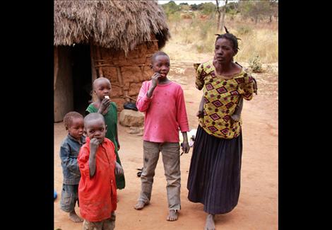  A young lady, not yet 30, with five children and no food is happy to see Jack Stivers and Meshack Itumo with food. The home is made from mud bricks.