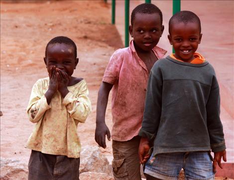 Boys share a hug in front of a school.