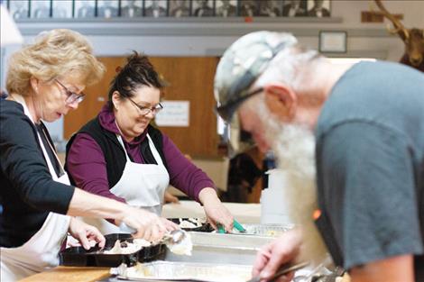 Volunteers at the Polson Community Thanksgiving Dinner assemble free turkey dinners for pick up at the Elks Lodge on Thanksgiving Day.