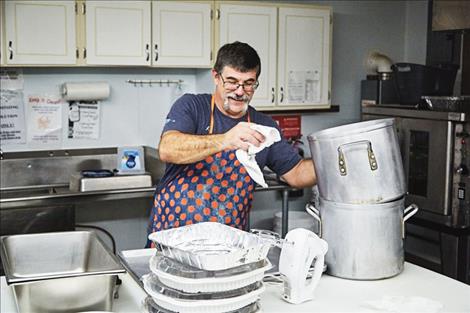 A volunteer at the Ronan Thanksgiving dinner cleans up in the kitchen.