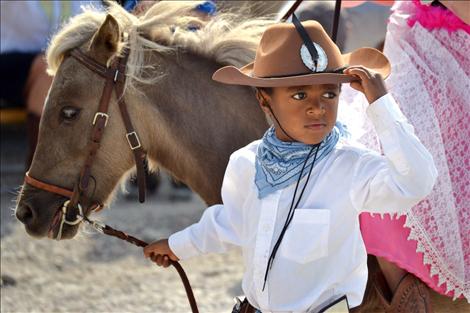 Little cowboy Abul Learn, 5, leads a horse around the entire parade course with his sister, Eve, 9, riding along.