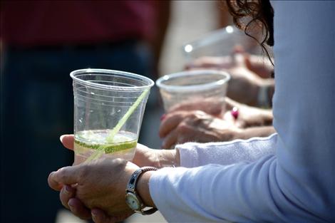 Friends share a handrail and beverages at the Idle Spur in Dayton as the parade passes by.