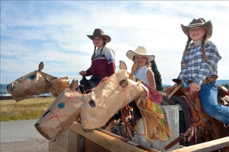 With paper faces and baling twine halters, trusty steeds support Yzabel, Eden and Coral Mergenthaler in the Dayton Daze parade.