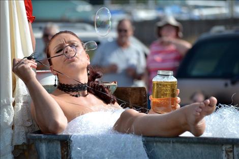 Dance Hall Girl Rachel Schreiner rides in an old bathtub on the prize-winning float, unSoiled Dove.