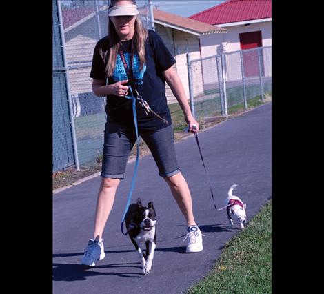Dawn Faialaga, Brody, her Boston  terrier, and Chica head out for a few laps around the track at Linderman Elementary School.