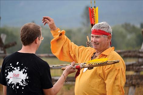 Flint knapper Don Safford, right, teaches Ben Kestner how shoot an atlatl.