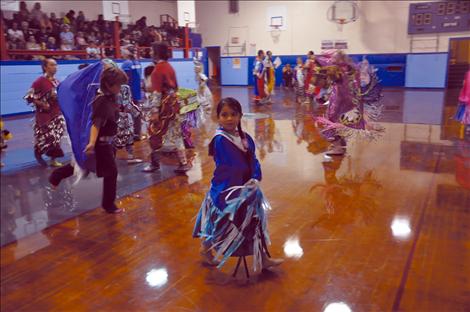 Kason Page, Tia Carpenter, and Destiny Hadley dance at a powwow. 