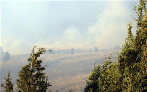Below, top left, a line of burning grass and other fuels points towards Kerr Dam as it burns up the side of the Flathead River.
