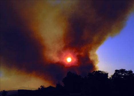 Below, bottom left, plumes of black smoke from the Irvine Flats fire veil the sunset on Sept. 16.