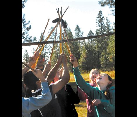 Children laugh as their sticks tangle in a game of double ball at the People’s Center. 