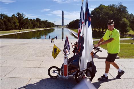 Lewis walks past the Washington Monument and reflecting pool.